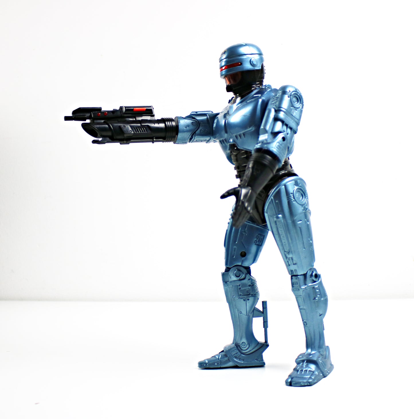 RoboCop action figure holding a gun on a white background
