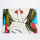 A pop art style print or poster showing a close-up illustration of a woman with yellow hair, red lips, and a hand covering part of her face, displayed against a plain white wall. IKEA Solmyra print 1999