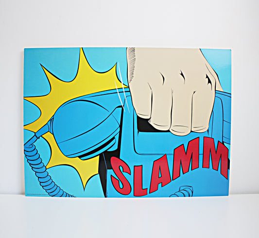 A square pop-art style print or poster showing a hand slamming a blue telephone receiver, with a yellow comic burst and the word "SLAMM" in red, photographed against a light gray wall and white surface. IKEA 1990s art. Vintage