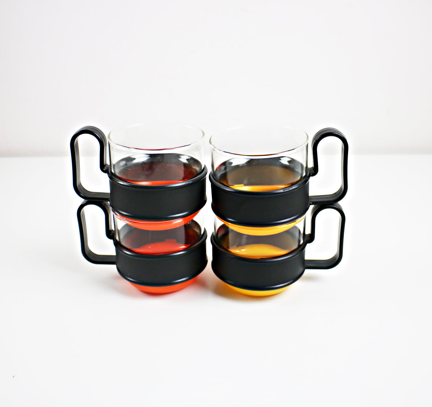 Pairs of modernist Pyrex Brasilia - glass and plastic cups - black and orange or black and yellow