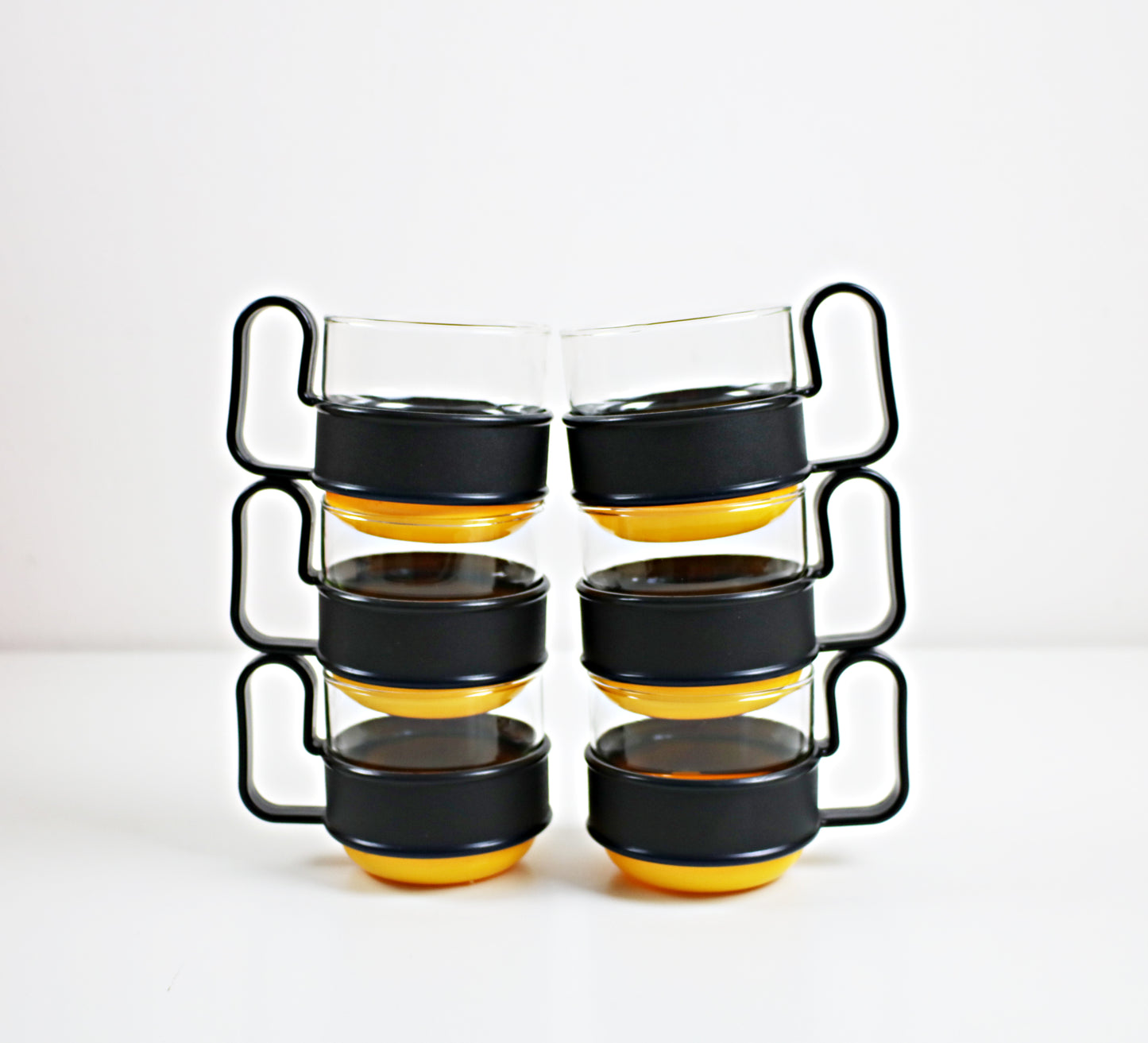 Pairs of modernist Pyrex Brasilia - glass and plastic cups - black and orange or black and yellow